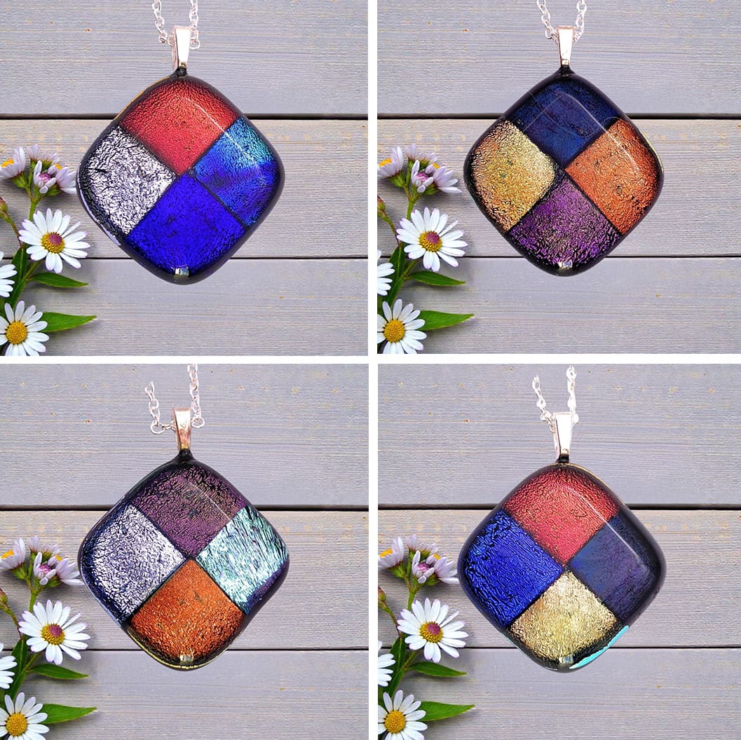 Four square-shaped glass pendants with colorful geometric patterns, each placed next to white daisies on a wooden surface.