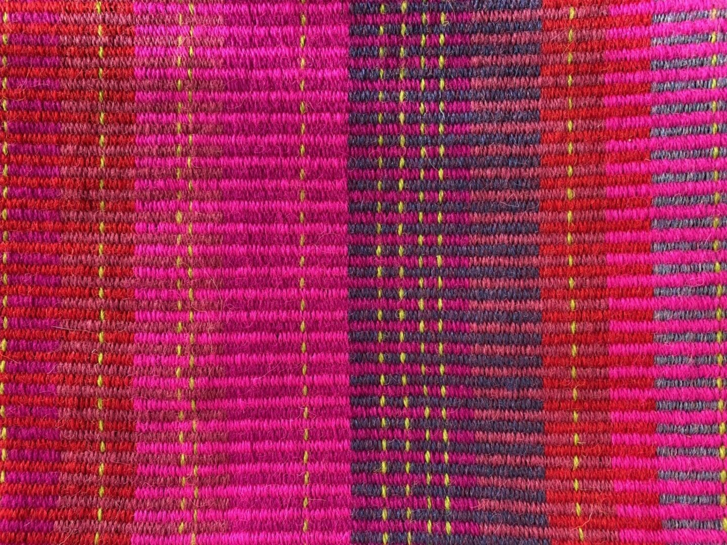 Large rectangular hand woven wool cushion ,featuring fuchsia pinks, warm reds and oranges. - Image 4