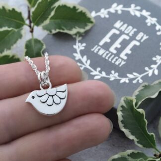 Handmade argentium sterling silver daisy bird pendant necklace shown on hand for scale with Made By Fee presentation jewellery box