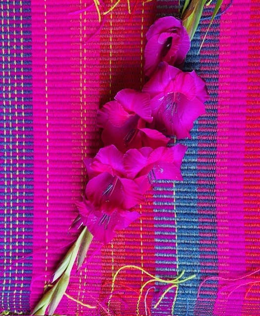 Large rectangular hand woven wool cushion ,featuring fuchsia pinks, warm reds and oranges. - Image 3