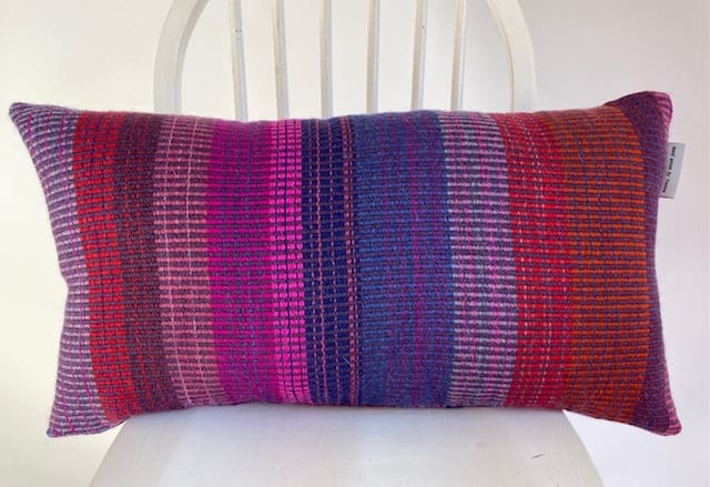Large rectangular hand woven wool cushion ,featuring fuchsia pinks, warm reds and oranges. - Image 6