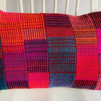 A colourful, patchwork design handwoven wool cushion