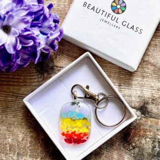 A brightly coloured striped fused glass rainbow keyring