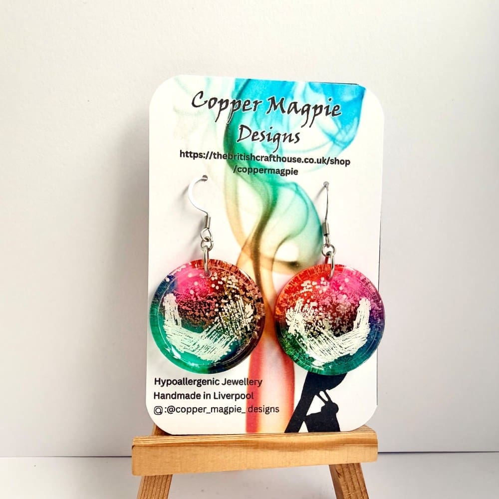 Colourful rainbow earrings of petri dishes with streaking pattern. Displayed on a branded Copper Magpie Designs Card. Earrings are hung on hypoallergenic surgical steel hooks.