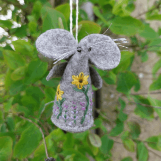 A handmade grey felt mouse with an embroidered design of sunflowers