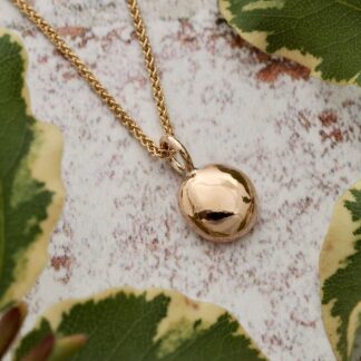 A 1g solid 9ct yellow gold shiny pebble drop pendant necklace shown on a 1mm profile gold spiga chain