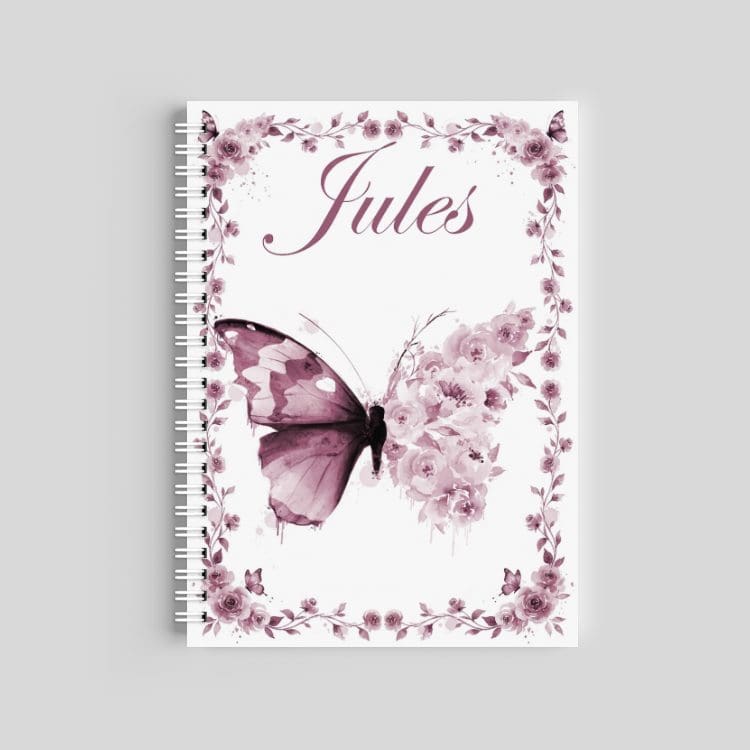 A spiral-bound notebook with a white cover featuring a large purple butterfly and soft watercolor flowers. The name "Mya" is printed in a clean black font at the bottom.