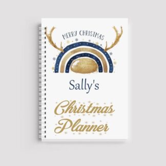 A spiral-bound notebook with a white cover. It features a navy and gold rainbow with reindeer antlers at the top, the name "Sally's" in navy, and "Christmas Planner" in gold script at the bottom.