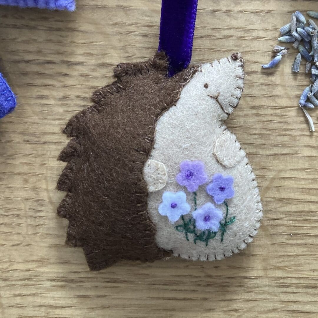 Close up of my lavendar filled hedgehog showing the 4 purple flowers and it's cute face
