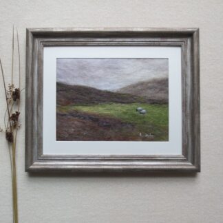 Under grey skies and brooding hills, two sheep graze peacefully on a lush green pasture.