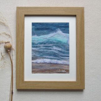 Aqua blue wave with white froth tip crashing onto a sandy beach.