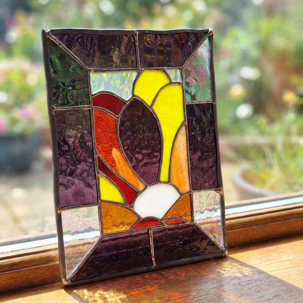 Side angle of stained glass panel standing on windowsill