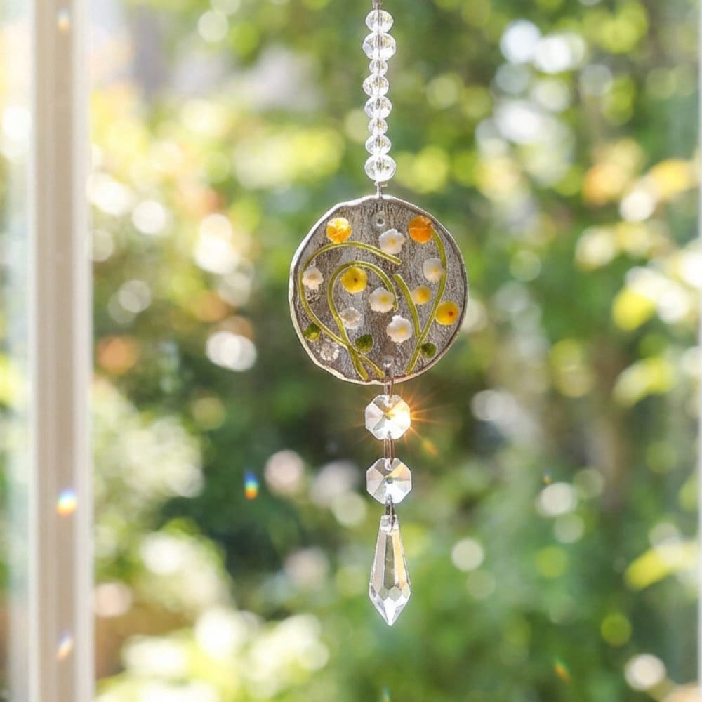 Crystal prism rainbow suncatcher hanging in a sunny window with soft green background