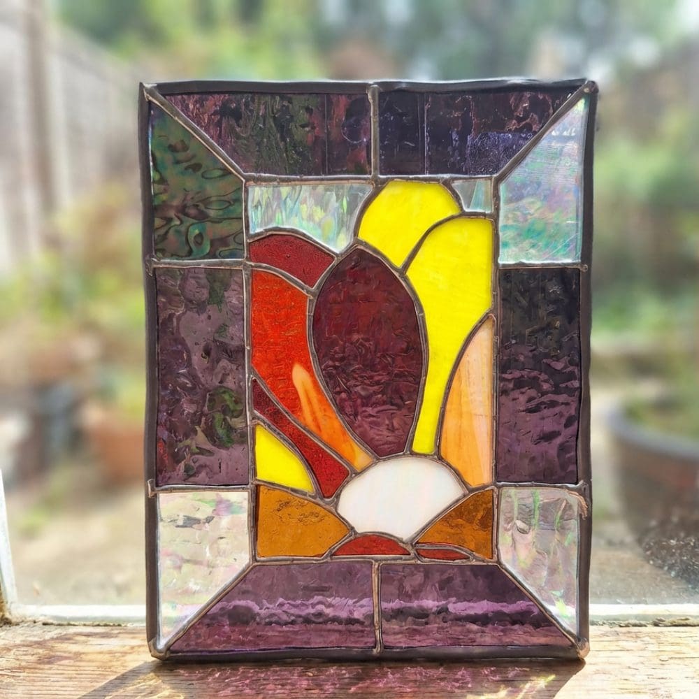 Freestanding stained glass panel showing light shining through colours
