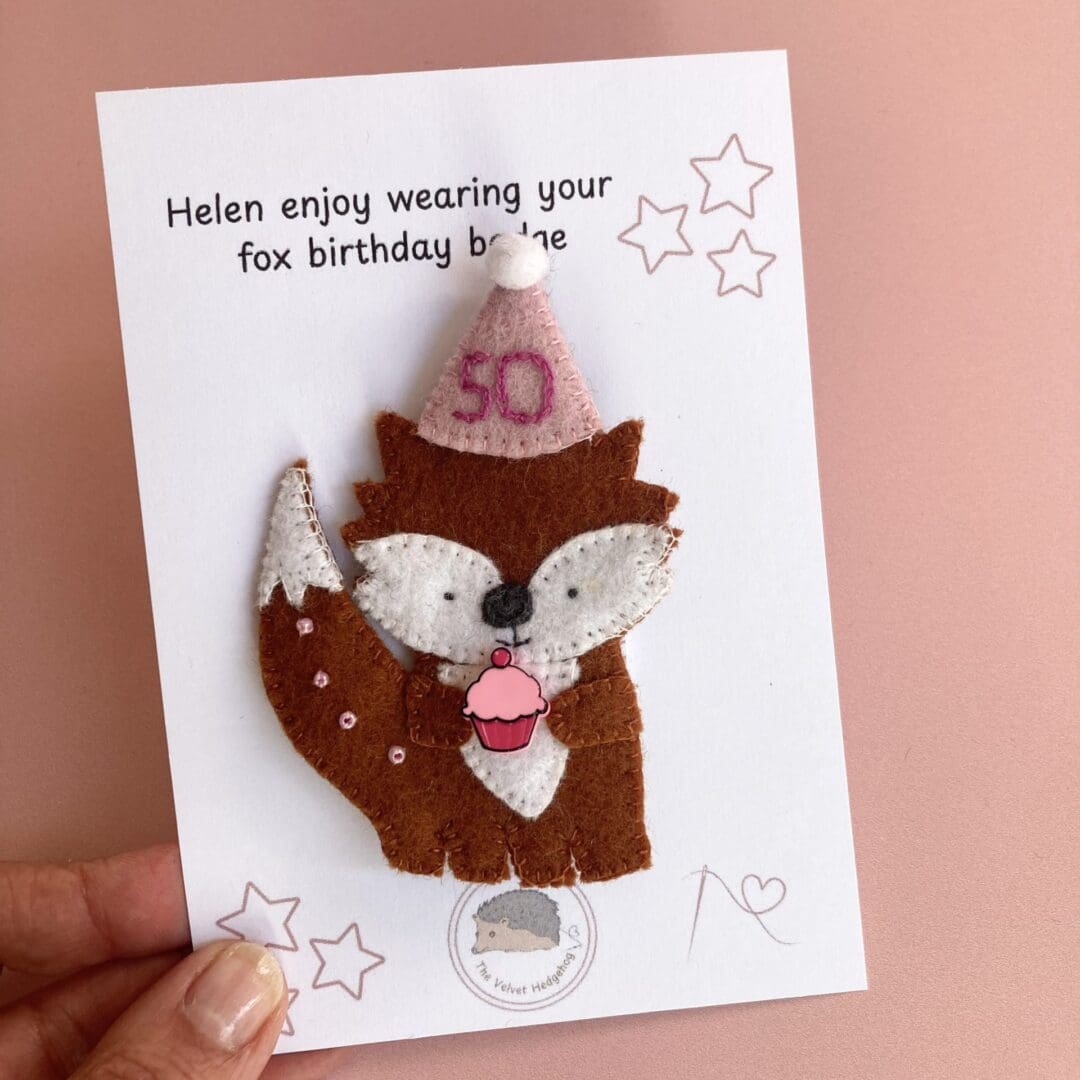 Me holding the fox brooch on the presentation card