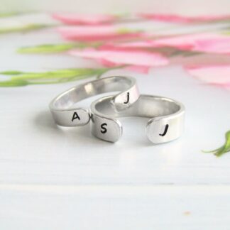 A hand-stamped aluminium cuff ring in either 4mm or 6mm width with a single initial at either end of the cuff.