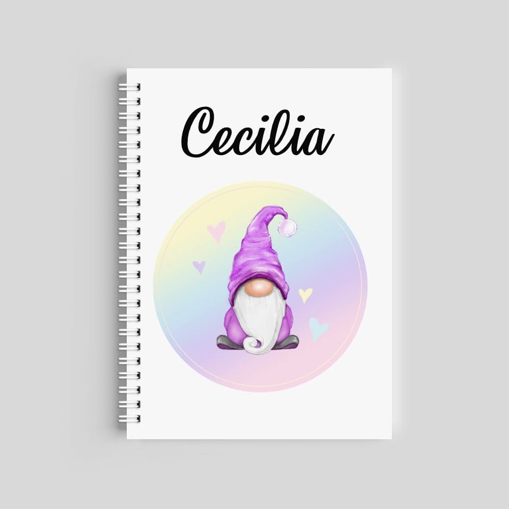 A spiral-bound notebook with a white cover. It features the name "Cecilia" at the top and a central illustration of a gnome with a purple hat inside a soft pastel rainbow circle with hearts.