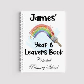 A spiral-bound A5 notebook with a white cover featuring a watercolor rainbow being painted by a brush. The text reads "James' Year 6 Leavers Book" and "Coleshill Primary School," with "Class of 2026" written across the rainbow arc.