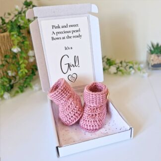 baby girl gender reveal announcement with handmade crochet baby booties