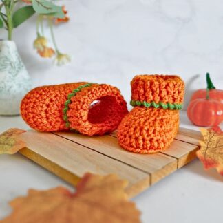 crochet pumpkin baby booties, in a spice colour with green edging