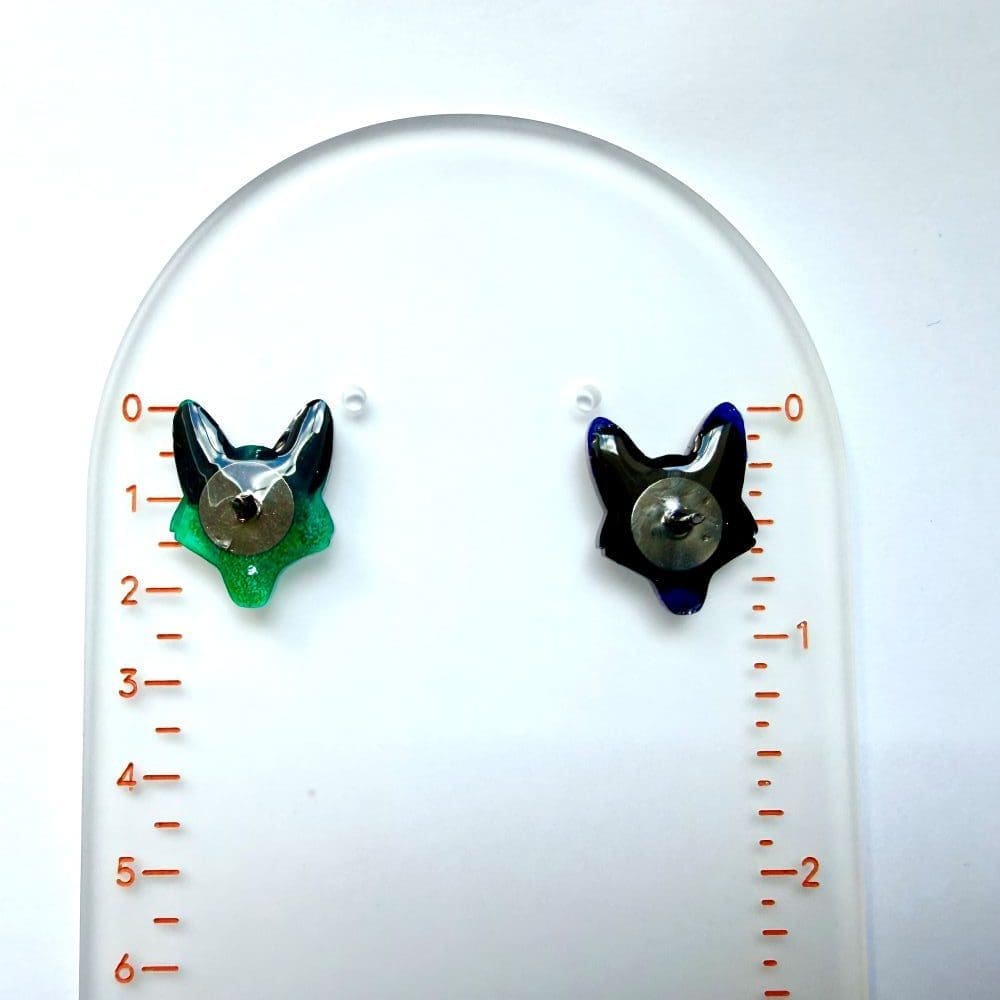 Scale shot of handmade fox and wolf glitter resin pin badges next to a ruler by Copper Magpie Designs Liverpool UK