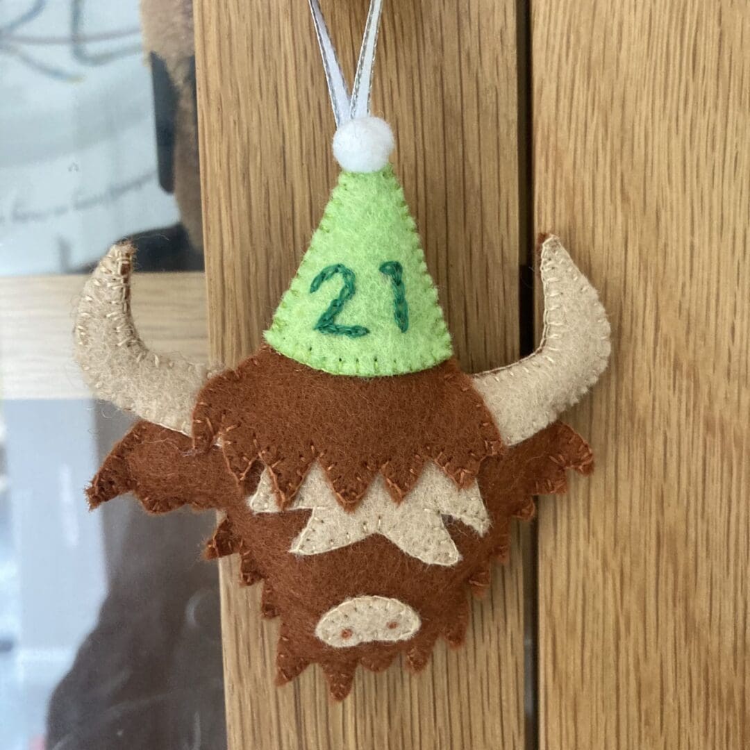 Highland cow has a ribbon so it can be hung up and kept