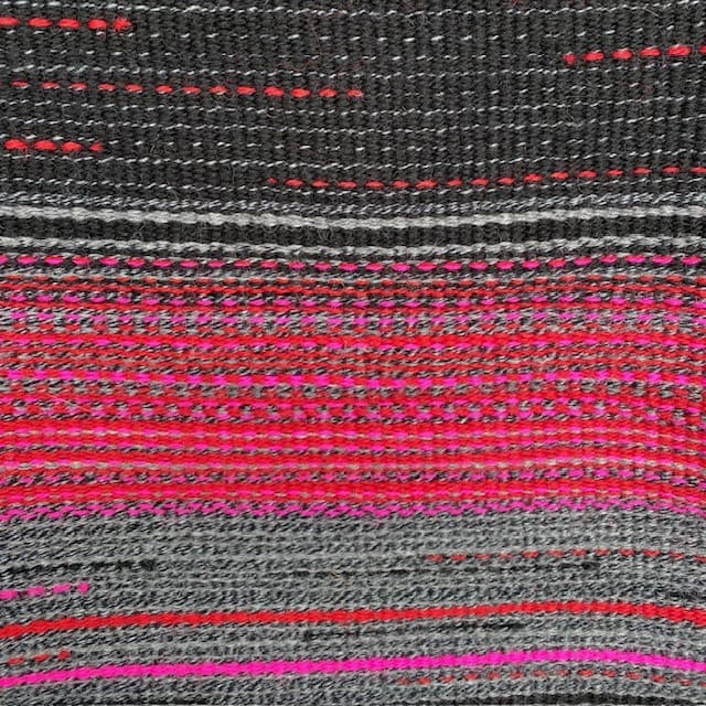 Contemporary hand woven wool cushion in a range of warm reds, soft greys and hot pinks. - Image 6