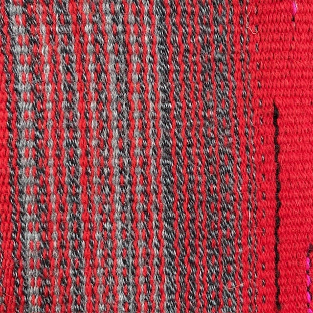 Contemporary hand woven wool cushion in a range of warm reds, soft greys and hot pinks. - Image 7