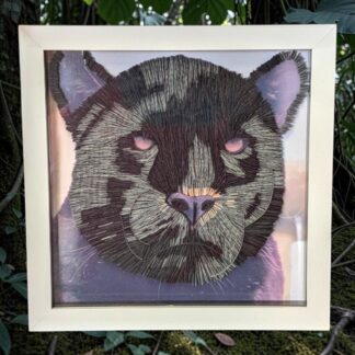 A quilled photo of the face of a Jaguar. The picture is in a white box frame.