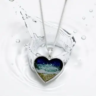 Heart shaped sterling silver ocean resin pendant with beach scene from Sand and Spirit, a British handmade brand creating ocean inspired resin jewellery, coastal gifts and beach inspired decor.