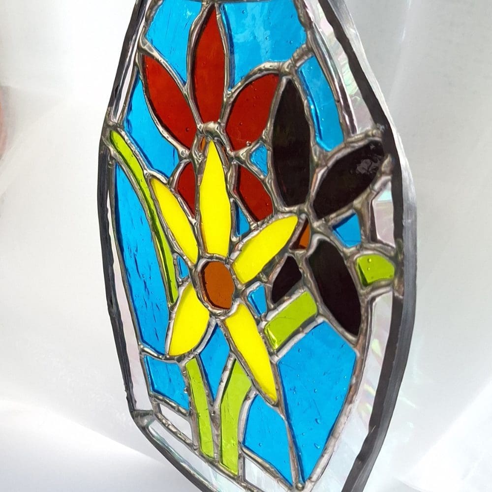 Handmade stained glass suncatcher gift wrapped in white tissue paper with purple ribbon