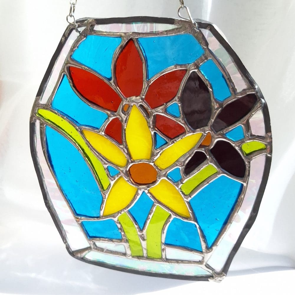 Stained glass window decoration with daffodil design in yellow red and turquoise